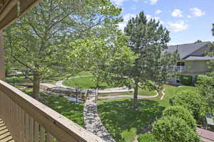 View of grassy yard with a balcony