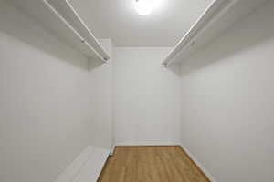 Walk in closet with light wood-style floors
