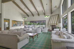 Living room featuring high vaulted ceiling, beam ceiling, a large fireplace, and dark carpet