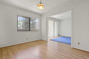 Spare room featuring wood finished floors and crown molding