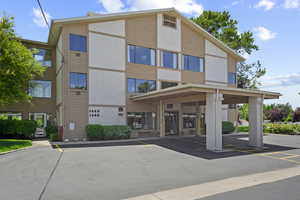 View of building exterior with covered and uncovered parking