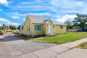 Bungalow-style home featuring a shingled roof, driveway, and a front yard