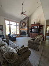 Living room with high vaulted ceiling, a stone fireplace, ceiling fan, and recessed lighting