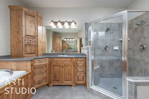 Primary bathroom with a stall shower, vanity, and tile patterned floors