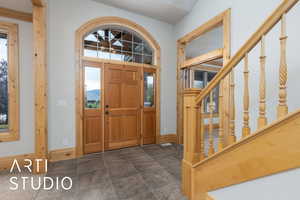 Foyer with baseboards and dark stone finish flooring