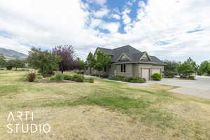 Craftsman-style home with stone siding, an attached garage, driveway, and a front lawn