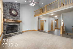 Unfurnished living room with carpet flooring, recessed lighting, a stone fireplace, a high ceiling, and ceiling fan