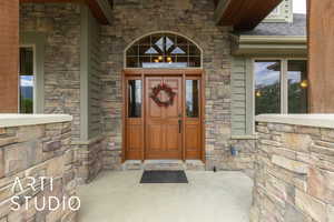 Property entrance with stone siding and covered porch