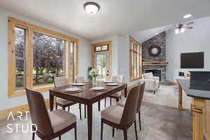 Dining area with lofted ceiling, a fireplace, and ceiling fan