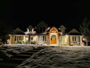 Craftsman inspired home featuring stone siding, covered porch, a standing seam roof, and a metal roof