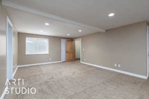 Carpeted empty room with recessed lighting and beamed ceiling