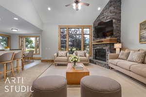 Living area featuring a fireplace, ceiling fan, recessed lighting, high vaulted ceiling, and wood finished floors