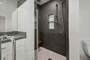 Full bath with vanity and tiled shower