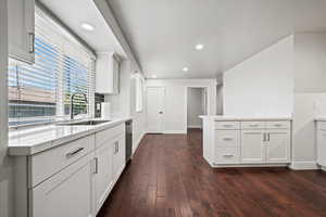 Kitchen with recessed lighting, dark wood-style floors, white cabinets, light stone counters, and dishwasher