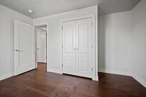 Unfurnished bedroom with hardwood / wood-style floors and a closet