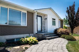Doorway to property featuring brick siding