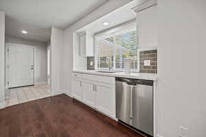 Kitchen featuring dishwasher, tasteful backsplash, recessed lighting, dark wood-style floors, and light countertops