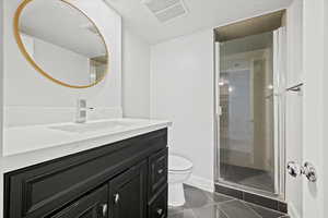 Full bath featuring vanity, a stall shower, and tile patterned flooring
