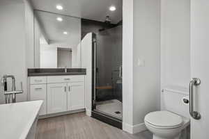Full bathroom with recessed lighting, a stall shower, vanity, and a freestanding tub