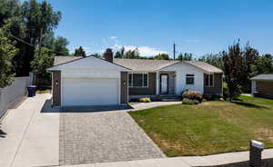 Ranch-style home featuring driveway, board and batten siding, a garage, and brick siding
