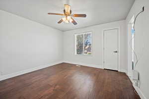 Empty room with dark wood-type flooring and ceiling fan
