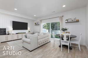 Living room with light wood-style flooring and recessed lighting