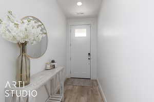 Doorway featuring light wood-type flooring and recessed lighting