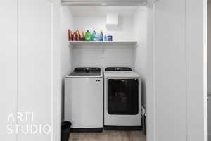 Laundry area featuring independent washer and dryer and light wood finished floors