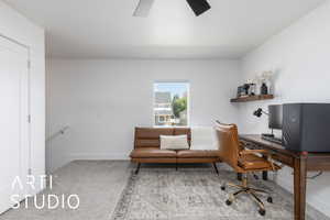 Carpeted office with a ceiling fan and baseboards