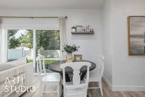 Dining room with wood finished floors and healthy amount of natural light