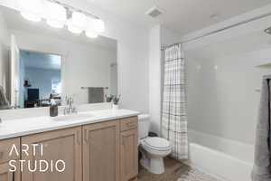 Bathroom featuring vanity, wood finished floors, and shower / bathtub combination with curtain