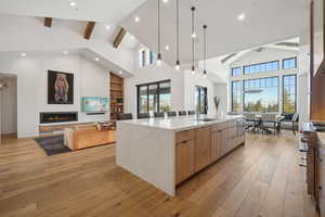 Kitchen featuring modern cabinets, high vaulted ceiling, beam ceiling, open floor plan, and a large island