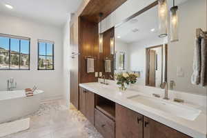 Bathroom with double vanity, a soaking tub, and recessed lighting