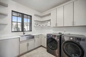 Laundry area featuring separate washer and dryer and cabinet space
