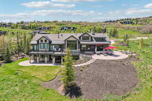 Rear view of house with a patio area and stone siding