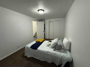 Carpeted bedroom featuring baseboards and a closet