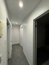 Hallway with dark colored carpet and recessed lighting