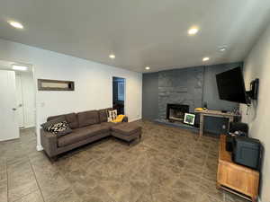 Living area featuring a stone fireplace and recessed lighting