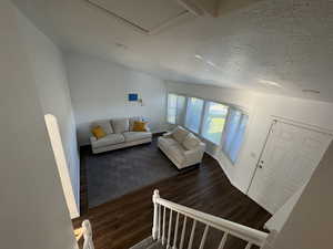Living room featuring dark wood-style floors and a textured ceiling