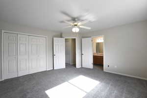 Unfurnished bedroom with carpet, a closet, ceiling fan, and connected bathroom