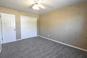 Unfurnished bedroom with carpet floors, a closet, and ceiling fan