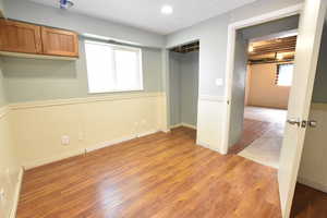 Unfurnished bedroom featuring light wood-type flooring, multiple windows, a closet, and recessed lighting