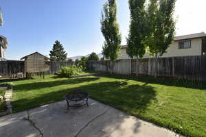 Fenced backyard with a patio and an outdoor fire pit