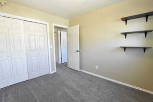 Unfurnished bedroom featuring carpet and a closet