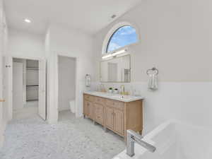 Bathroom featuring double vanity and a garden tub