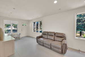 Living area featuring healthy amount of natural light, concrete floors, and recessed lighting
