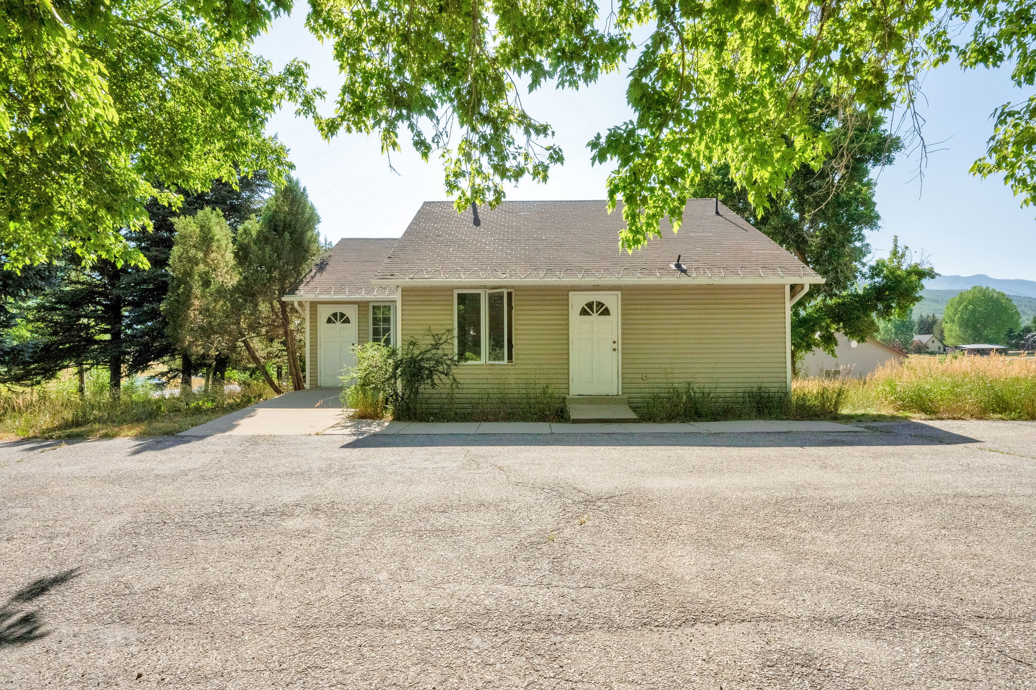 View of front of house featuring a garage, roof with shingles, and driveway