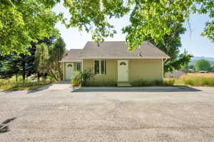 View of front of house featuring a garage, roof with shingles, and driveway