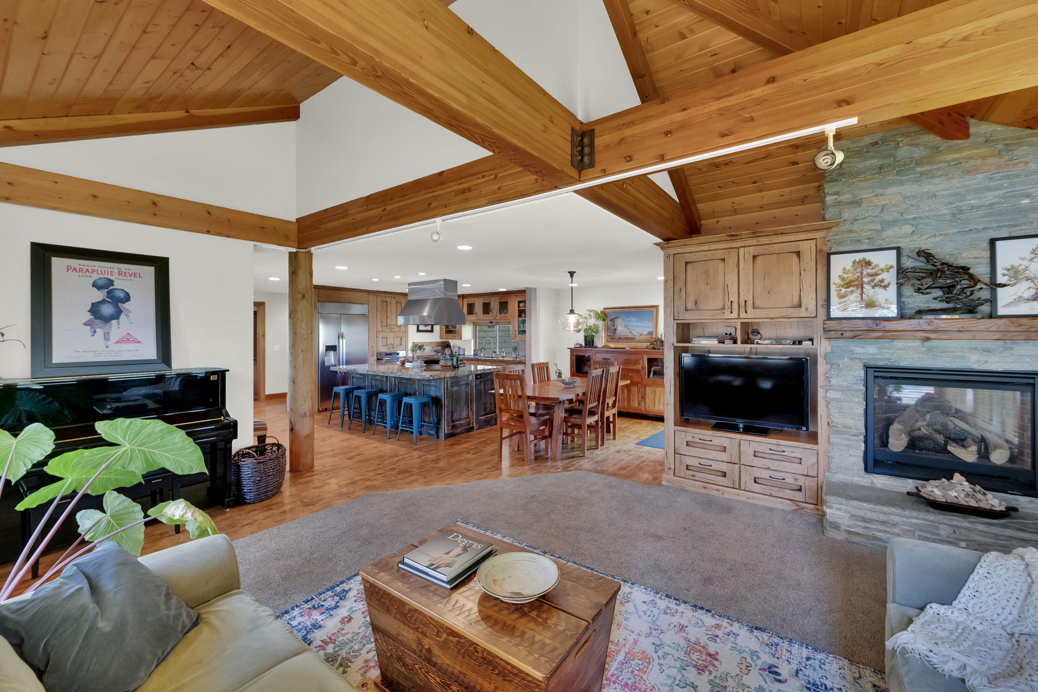Living area featuring high vaulted ceiling, light wood-style floors, a fireplace, a wooden ceiling with exposed beams, and recessed lighting