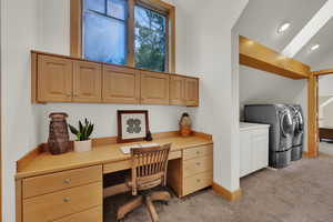 Office area featuring washer and clothes dryer, built in study area, light colored carpet, vaulted ceiling, and recessed lighting